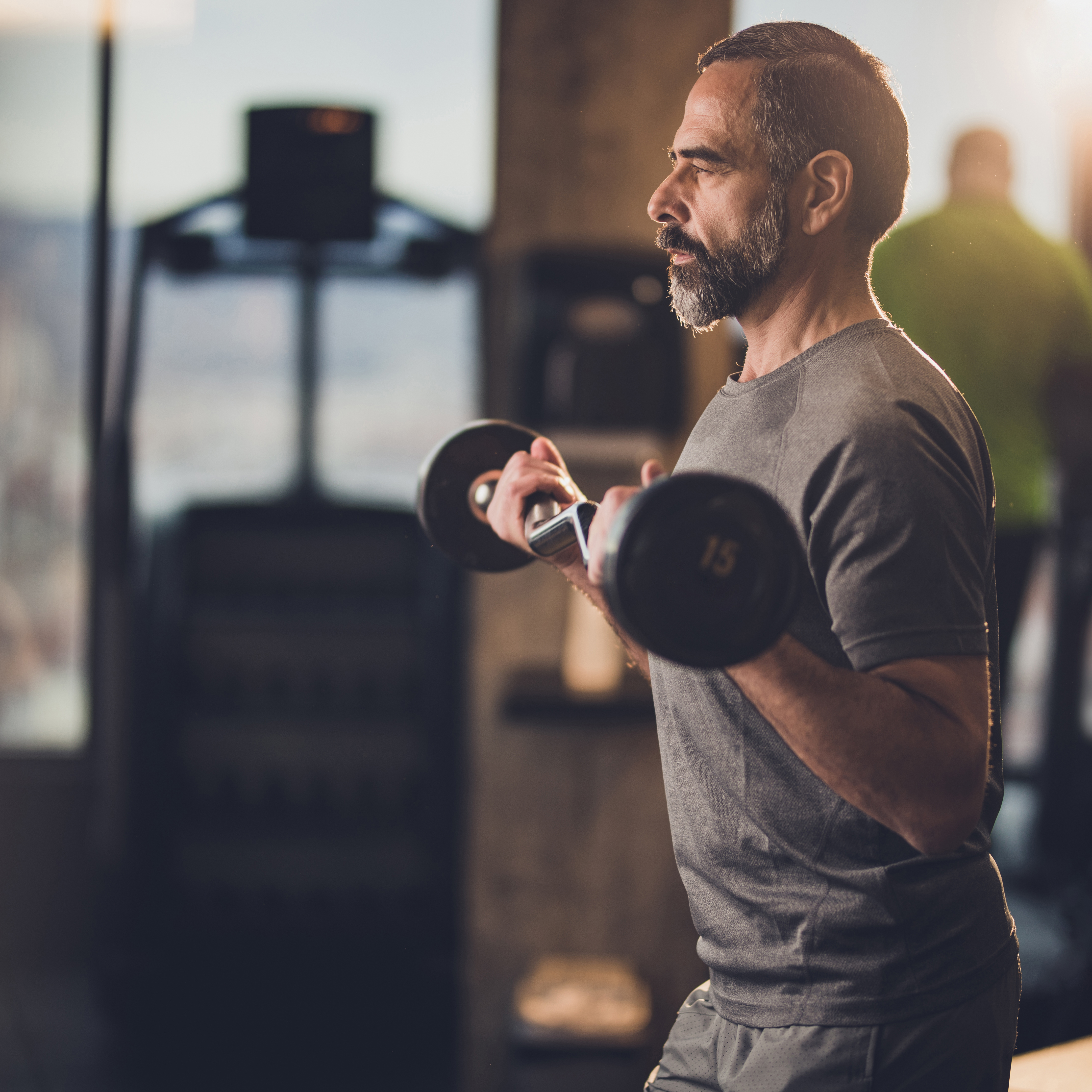 一个健康成熟的男人在健身房举重。