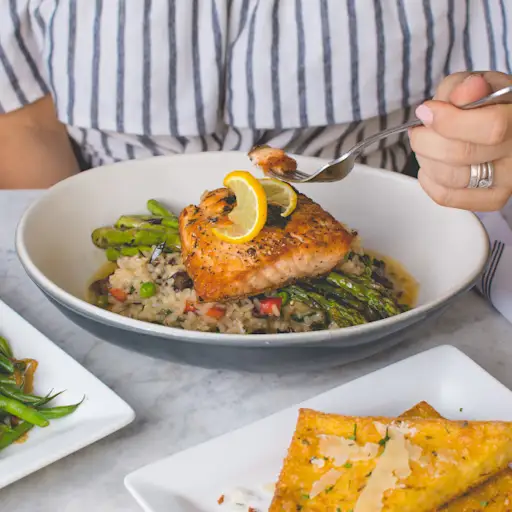 woman eating fish veggies and whole grains