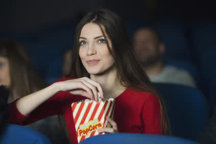 女子在电影吃爆米花。