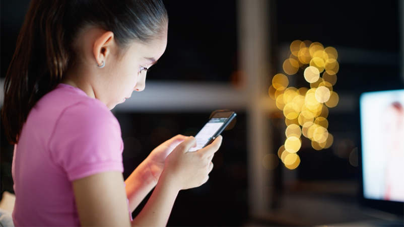 年轻女孩使用手机上的社交媒体。