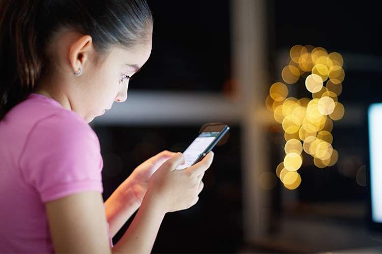 年轻女孩使用手机上的社交媒体。