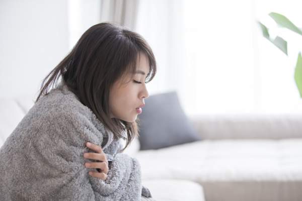 sick woman wrapped in blanket