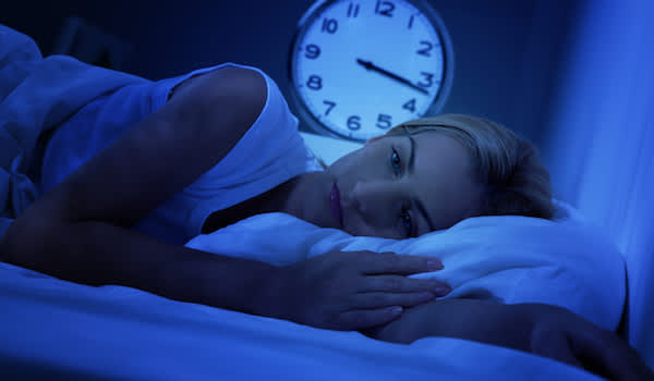 女人躺在床上失眠黑暗的痛苦。