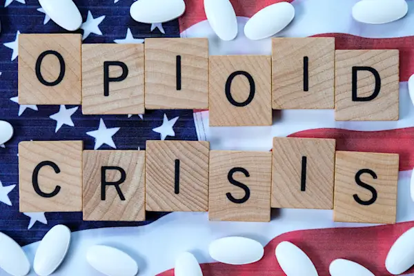 药丸和手工瓷砖拼写“阿片危机”。