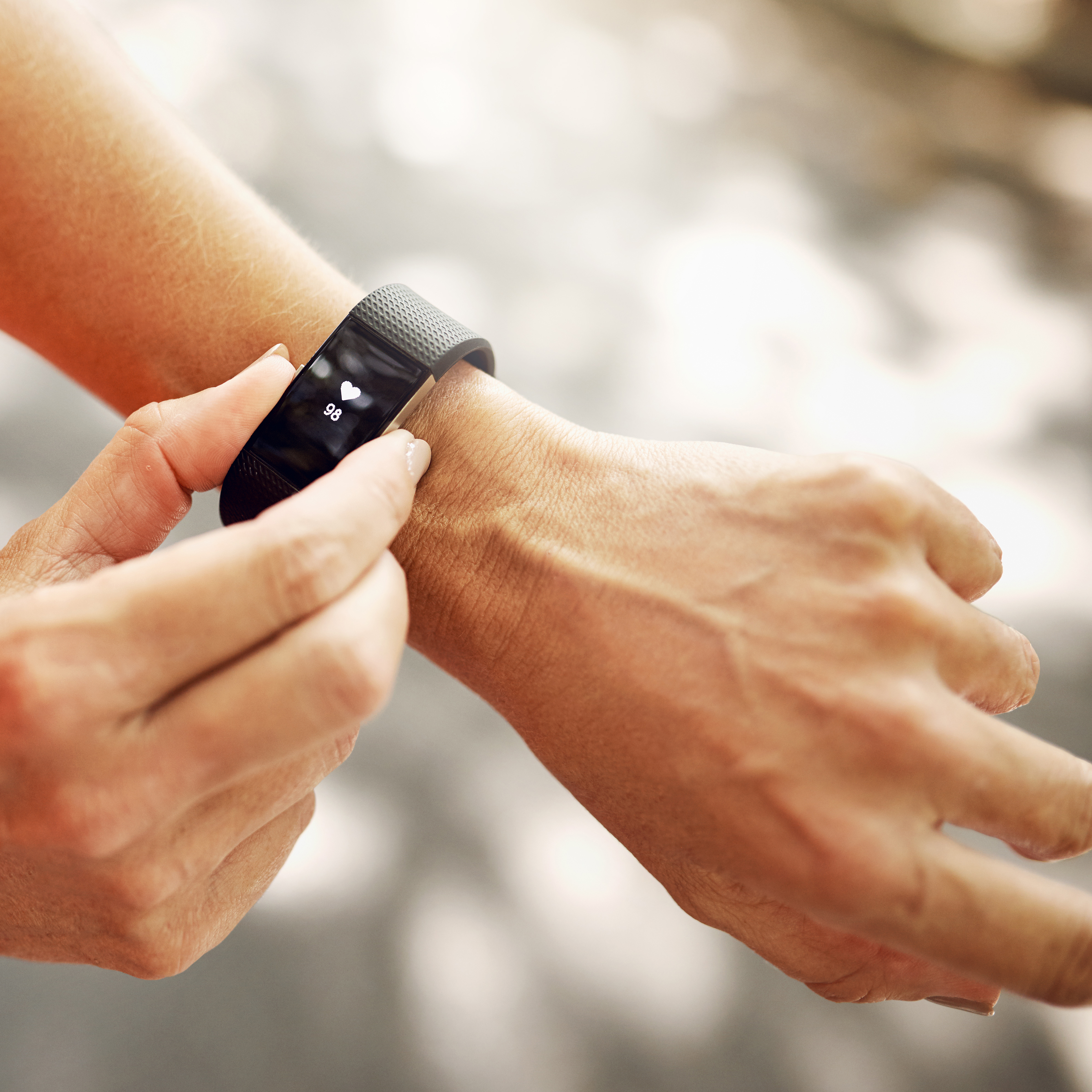 一个女人检查她的健身追踪器的特写