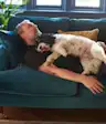 Man sleeping on the couch with his dog