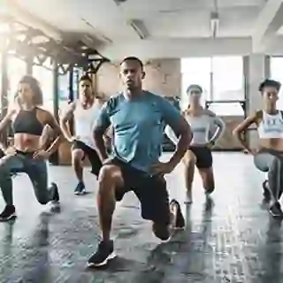Group of people doing isometric lunges in exercise class.
