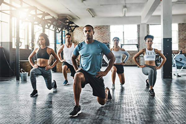 一群人在健身课上做等距弓步。