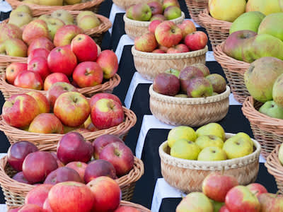 农贸市场的篮子里装着各种各样的苹果。