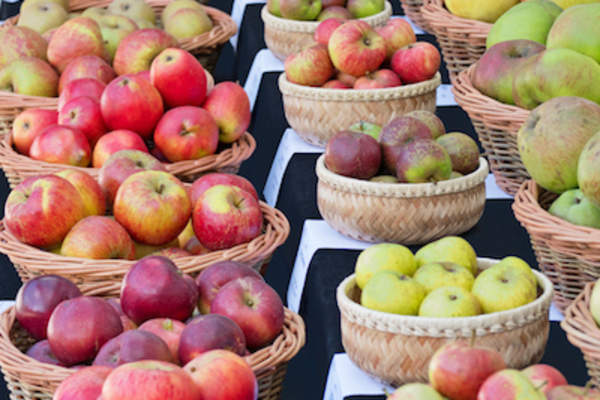 农贸市场的篮子里装着各种各样的苹果。