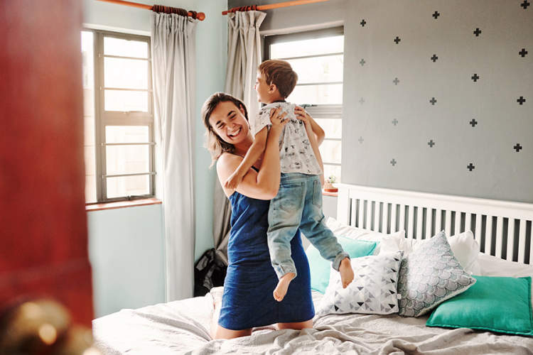 Mother and son jumping on the bed
