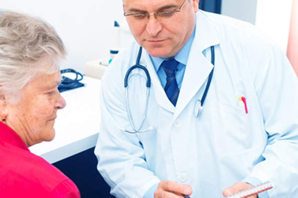 医生正在和一位年长的女病人谈话。