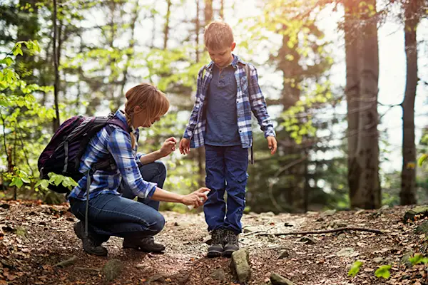 母亲在儿子身上喷洒杀虫剂。