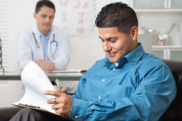 西班牙裔病人填写表格,在医生的办公室。