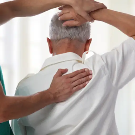 理疗师帮助病人改善肩部活动范围。