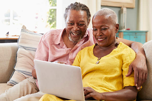 老年夫妇在笔记本电脑上研究医疗保险。