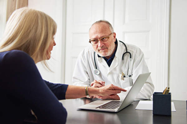 女人跟医生,使用笔记本电脑。