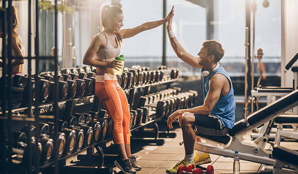 男人和女人高五在健身房锻炼后。