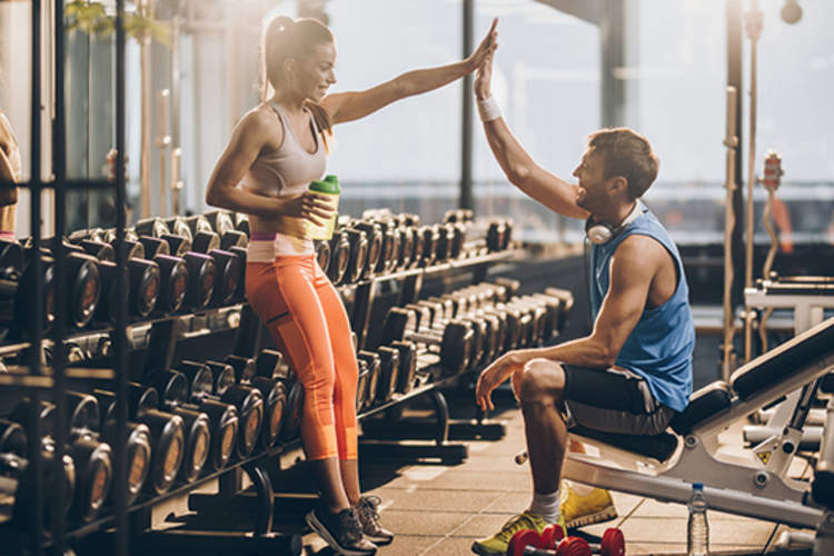 男人和女人高五在健身房锻炼后。