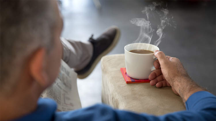 男人端着一杯热茶。