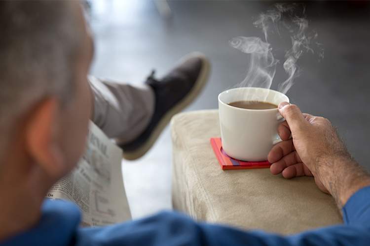 男人端着一杯热茶。