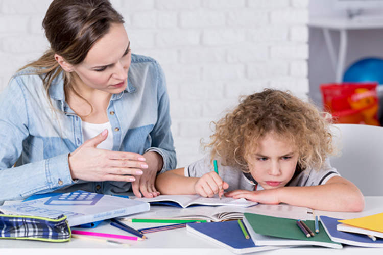 母亲帮助年幼的儿子做作业,注意力不集中。