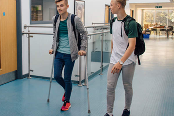 学生拄着前臂拐杖四处走动。