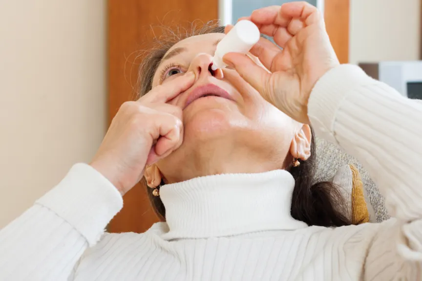 man with sinus spray