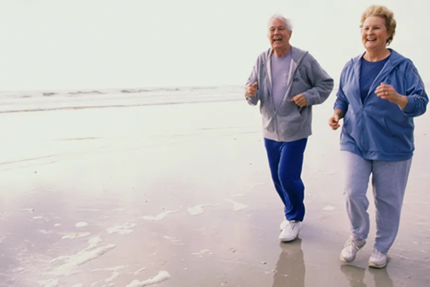 一对老年夫妇在沙滩上慢跑