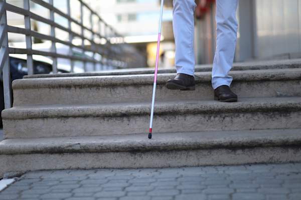 男子与白色拐杖走楼梯