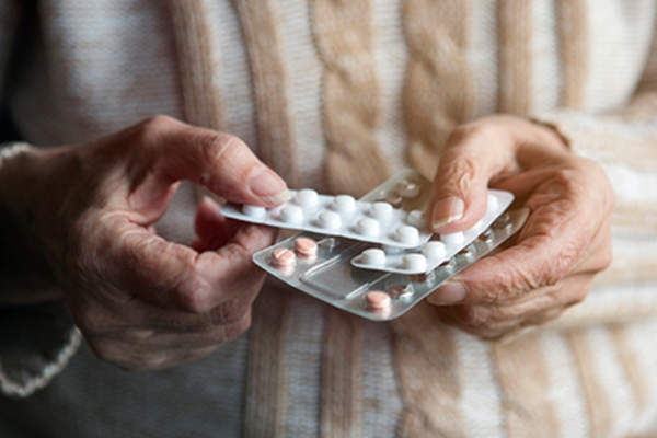 持有口服类风湿关节炎药物的老年妇女。