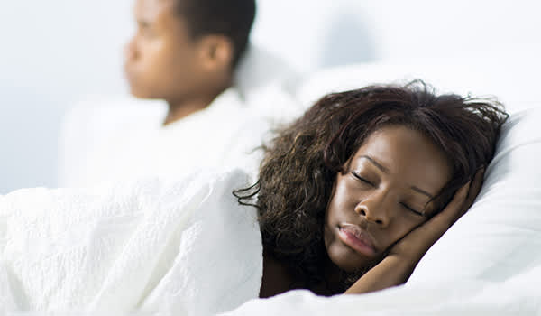 女人睡觉，而伴侣看电视图像。