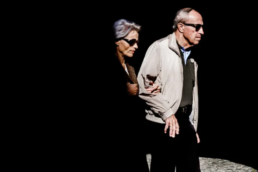 两个老年人戴着太阳镜走路