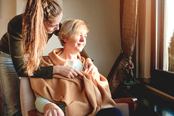 女人把毯子上的高级轮椅妇女。