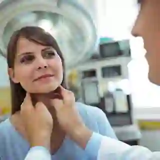 Woman getting a thyroid exam from a doctor.