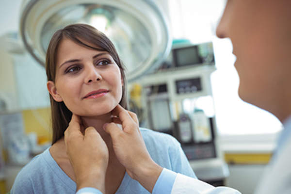女人正从一个医生的甲状腺检查。