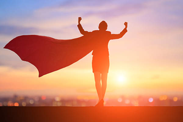 穿着超级英雄斗篷的自信女人。