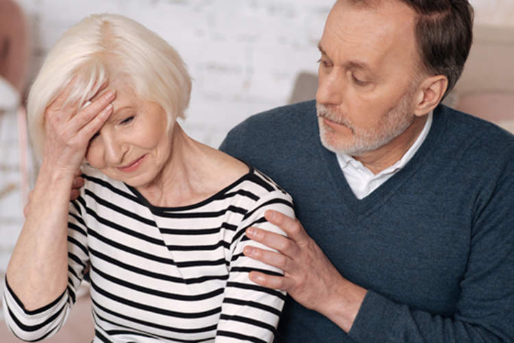Man supporting stressed woman with headache.