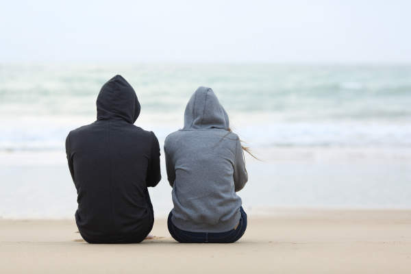 男人和女人坐在庄严的海滩