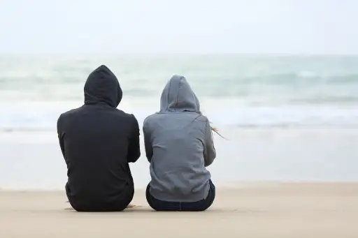 男人和女人庄严地坐在沙滩上