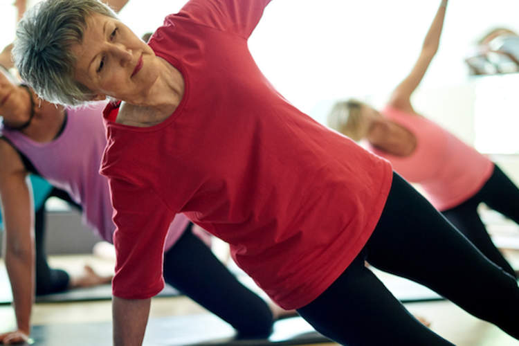 老年人与教练和健身球工作