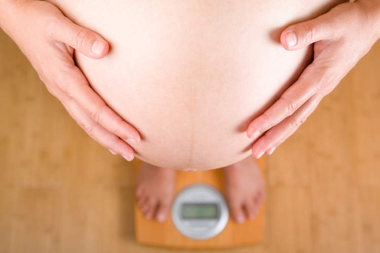 站在磅秤上的孕妇。