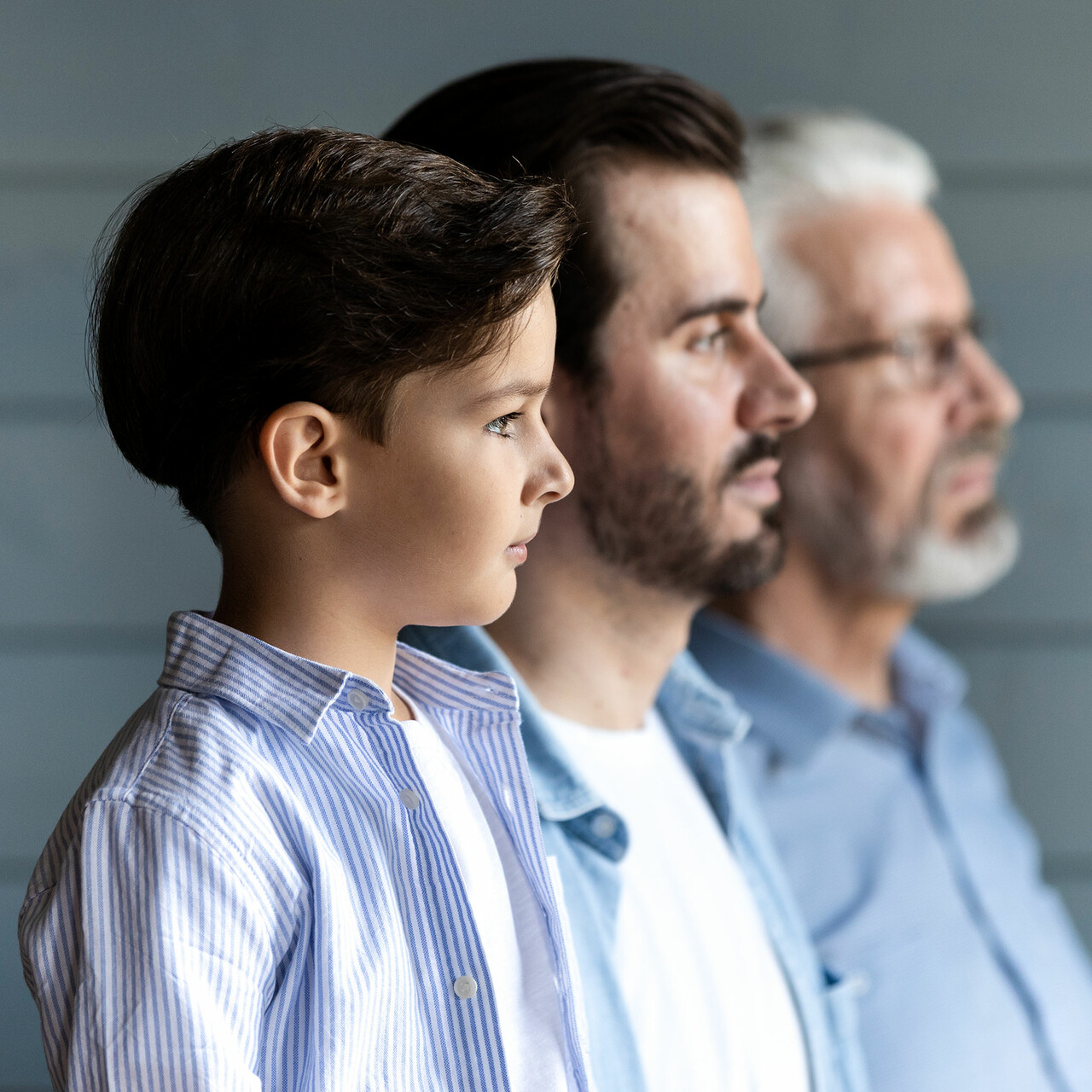一个男孩,他的父亲和祖父站在一排