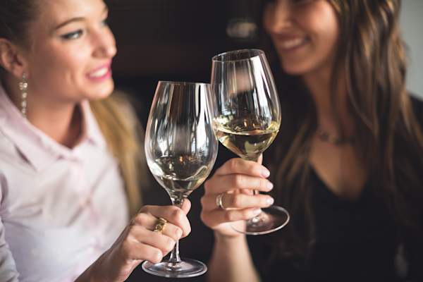 女人喝白葡萄酒。