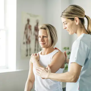 Physical therapist examining a patient's joints