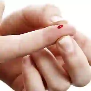 Squeezing a drop of blood from finger.