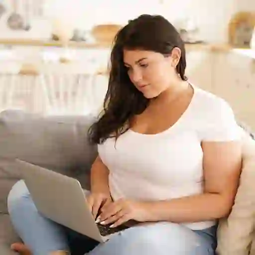 年轻超重的女人在笔记本电脑上