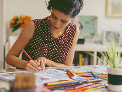 女性在成年着色书绘图。