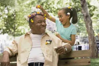 小女孩把花插在她爷爷的头发上