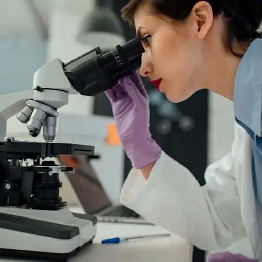 scientist looking through microscope